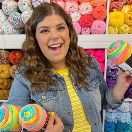 Kylee, owner and author of Okie Girl Bling 'N' Things, smiling holding yarn.